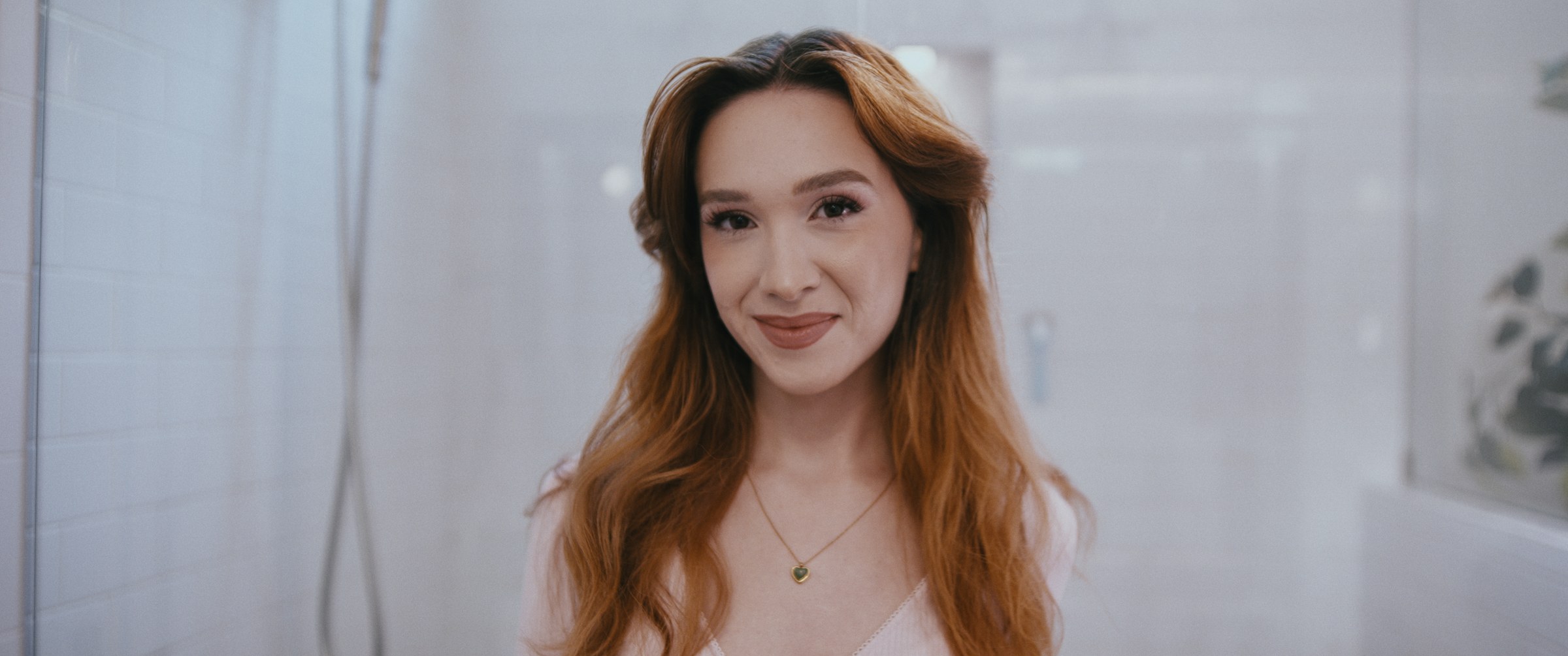 GLIMMR – Woman smiling at camera in bathroom