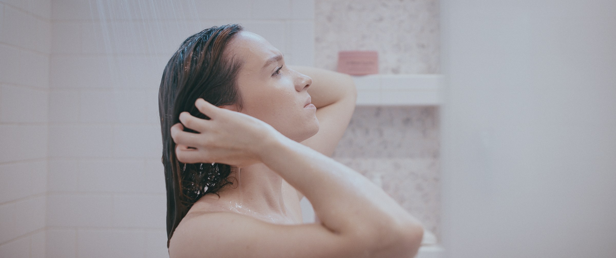 GLIMMR – Woman washing hair in shower